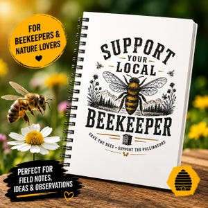 Op de afbeelding: Een wit spiraalgebonden notitieboek met de tekst "SUPPORT YOUR LOCAL BEEKEEPER" en een gedetailleerde illustratie van een bij. Het notitieboek heeft zwarte tekst en een zwarte spiraalbinding. Extra tekst is "SAVE THE BEES".