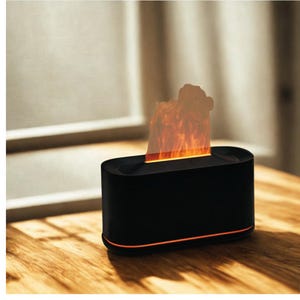 Pode incluir: Uma lareira de mesa preta e retangular com uma faixa de luz LED laranja na base. A lareira apresenta uma luz em forma de chama no topo, criando um ambiente acolhedor. É colocada sobre uma superfície de madeira.