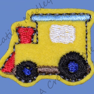 May include: Yellow felt applique of a school bus with a red front, blue windows, and black wheels.