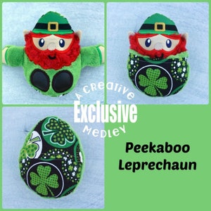 May include: A green and black fabric shamrock-patterned egg with a peek-a-boo opening revealing a plush leprechaun with a red beard, green hat, and green clothing. The text "Peekaboo Leprechaun" is written in black on a green background.