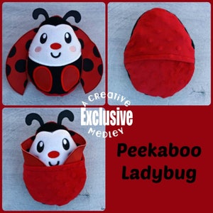 Op de afbeelding: Een rood en zwart lieveheersbeestje knuffel met een peek-a-boo-functie. Het hoofd van het lieveheersbeestje is wit met zwarte ogen en een rode neus. De vleugels van het lieveheersbeestje zijn rood met zwarte stippen. Het speelgoed is gemaakt van zacht materiaal en is perfect voor kinderen.