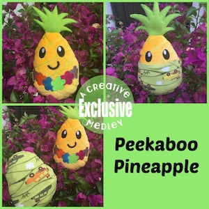 May include: A plush pineapple toy with a smiling face and a green leafy top. The pineapple is wearing a green and white patterned fabric around its middle. The text "Peekaboo Pineapple" is written in white on a green background.