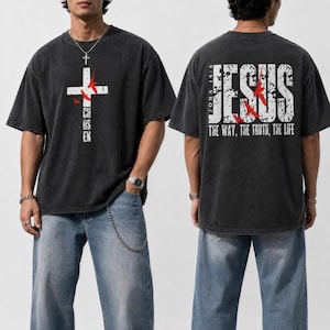 Puede incluir: Una camiseta gris carbón de manga corta con un gráfico de cruz blanca y pájaros rojos en el frente y el texto CHOSEN. La parte posterior muestra el texto JESUS THE WAY, THE TRUTH, THE LIFE con JOHN 14:6 y pájaros rojos en fuente blanca.
