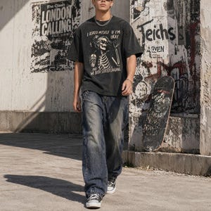 May include: A person wearing a black graphic t-shirt and blue jeans. The t-shirt features a skeleton design with the text "I ASKED MYSELF IF I'M OKAY AND WE BOTH STARTED LAUGHING". The jeans are a faded blue wash. The person is wearing black and white sneakers.