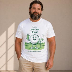 May include: White t-shirt with a green cartoon golf ball holding a beer, and a golf flag. The shirt has the text "TIME FOR ANOTHER ROUND" and "ON THE COURSE & AT THE BAR".