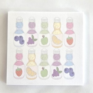 May include: A square notepad featuring a repeating pattern of ten illustrated glass bottles arranged in two rows. Each bottle contains a pastel-colored liquid and displays a fruit graphic, including blueberries, grapes, green apples, orange slices, and strawberries.