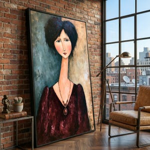 May include: A large framed painting of a person with dark hair and a long neck, wearing a deep burgundy dress and a pendant necklace. The figure is set against a textured background of muted blue and beige tones, displayed in a black frame.