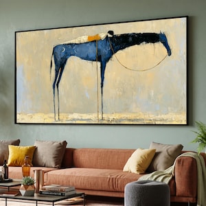 May include: A rectangular wall art print featuring a stylised, elongated blue horse with a black head and neck, carrying a figure in white and yellow on its back. The horse is depicted against a textured, light beige background with visible brushstrokes.