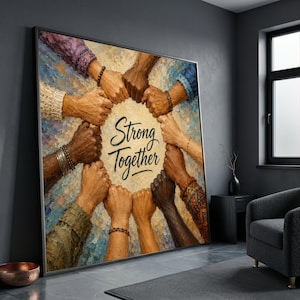 Può includere: Un'opera d'arte incorniciata raffigurante un cerchio di mani intrecciate con diverse tonalità di pelle. Le parole "Strong Together" sono scritte in elegante corsivo all'interno del cerchio. Il dipinto ha uno stile strutturato e impressionista con una tavolozza di colori neutri.