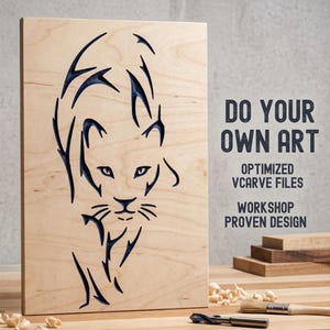 Puede incluir: Panel de madera clara con un diseño tallado de un felino en azul oscuro. El texto "DO YOUR OWN ART" es visible. El panel se muestra sobre una superficie de madera con herramientas y virutas de madera.