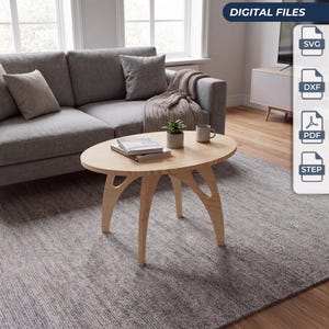 Könnte beinhalten: Ein ovaler Couchtisch aus hellem Holz mit drei geschwungenen Beinen und einer glatten Tischplatte. Auf dem Tisch stehen eine kleine grüne Topfpflanze und eine Keramiktasse. Das Bild enthält digitale Dateisymbole für SVG, DXF, PDF und STEP.