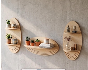 May include: Three light-colored wooden wall shelves with oval backings and arched decorative carvings at the bottom. The shelves hold small potted plants, books, and decorative figurines. The image includes the text DIGITAL FILES and file icons.