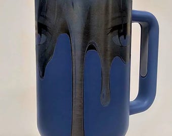 Puede incluir: Vaso aislado azul con asa y tapa. El vaso presenta un diseño gris oscuro de ojos y pintura goteando. La palabra "SLU" es visible en la parte inferior del vaso.