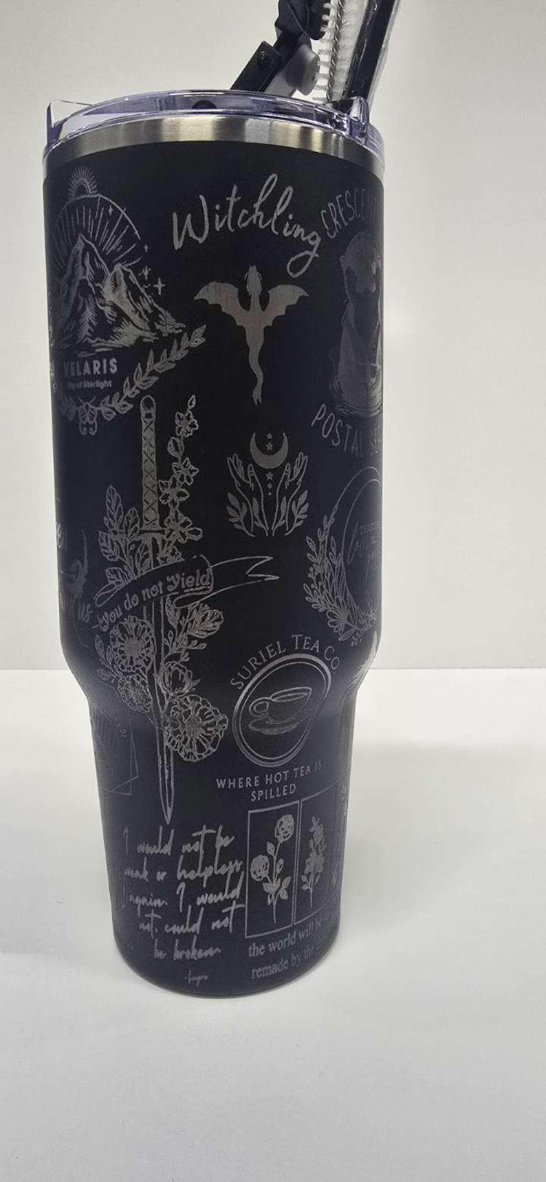 May include: Black tumbler with etched designs, including a dragon, sword, and text that reads "Witchling Crescent" and "You do not yield." Features a lid and straw. A unique gift for fans of fantasy and tea.