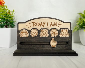May include: Wooden desk organizer with the text "TODAY I AM" and various emoji faces. The organizer is dark gray with a light wood top. Includes a slot for a hand emoji.