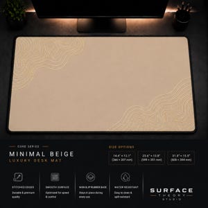 May include: A rectangular beige desk mat with a black border and embossed topographic line patterns in the top-left and bottom-right corners. The text reads Core Series Minimal Beige Luxury Desk Mat, Surface Theory Studio, and lists sizes in inches and mm.