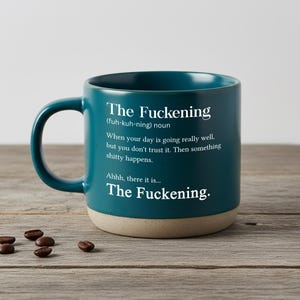 Op de afbeelding: Een blauwgroene keramische mok met een handvat en een gespikkelde beige onderkant. De mok is voorzien van witte tekst: The Fuckening (fuh-kuh-ning) noun. When your day is going really well, but you don't trust it. Then something shitty happens. Ahhh, there it is... The Fuckening.