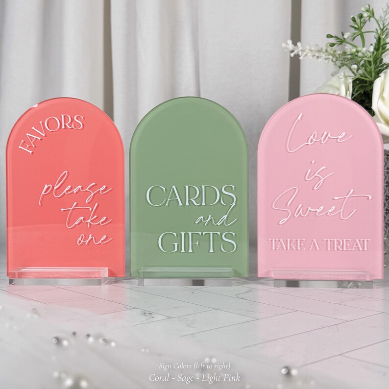 three rectangular signs with different colors and messages, placed on a white surface.