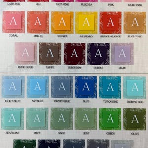 May include: A color chart featuring a variety of shades, each with a square background and a white letter "A". Colors range from dark red to stone, including pinks, blues, greens, and yellows. Each square has a floral pattern.