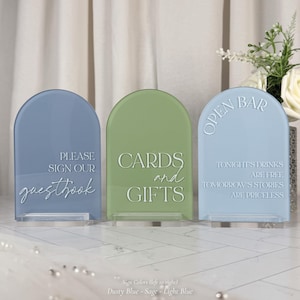 three rectangular signs with text on them, placed on a white surface.