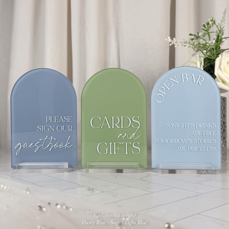 three rectangular signs with text on them, placed on a white surface.