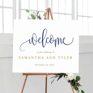 May include: White welcome sign with navy blue calligraphy that says "welcome" and gold text that says "to the wedding of SAMANTHA AND TYLER" and "November 19, 2017".