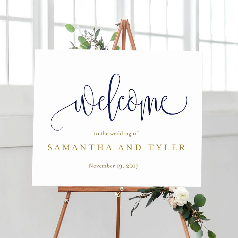 May include: White welcome sign with navy blue calligraphy that says "welcome" and gold text that says "to the wedding of SAMANTHA AND TYLER" and "November 19, 2017".