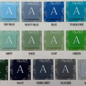 May include: A collection of square cards in various colors, each featuring the letter "A" in white. Colors include light blue, sky blue, dusty blue, blue, turquoise, and robin's egg. Other colors are seafoam, mint, sage, leaf, green, olive, pine, navy, dark grey, glacier, and stone.