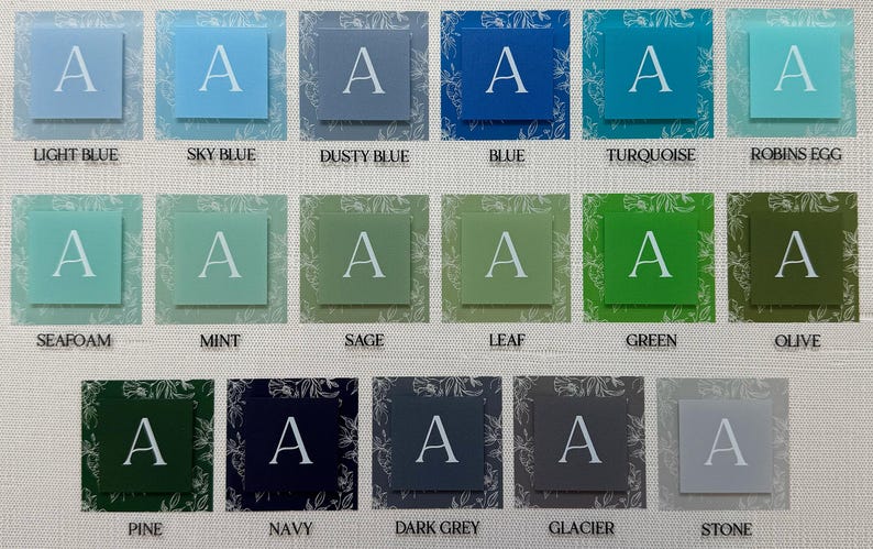 May include: A collection of square cards in various colors, each featuring the letter "A" in white. Colors include light blue, sky blue, dusty blue, blue, turquoise, and robin's egg. Other colors are seafoam, mint, sage, leaf, green, olive, pine, navy, dark grey, glacier, and stone.