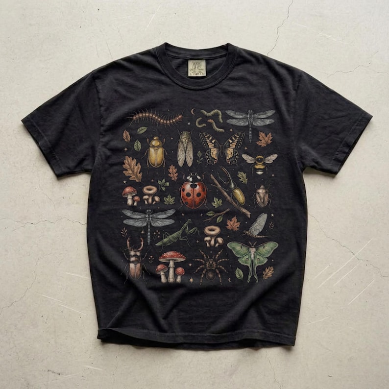 A vintage cottagecore print featuring a detailed collection of insects and woodland foliage. The layout centers on a large ladybug, surrounded by a centipede, dragonflies, a golden beetle, a cicada, a butterfly, a bumblebee, a praying mantis, a stag beetle, a spider, and a green luna moth. Interspersed among the detailed bugs are various red and brown mushrooms, autumn oak leaves, twigs, and tiny mystical stars. The artwork utilizes muted earthy tones for a classic nature aesthetic.