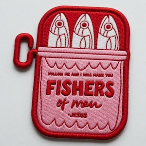 Op de afbeelding: Geborduurde patch met een rood sardineblik-ontwerp en drie witte vissen. De patch bevat de tekst "FOLLOW ME AND I WILL MAKE YOU FISHERS of men - JESUS" in het rood op een roze achtergrond.