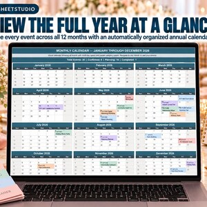 May include: A laptop screen displaying a 2026 annual calendar with twelve monthly grids. The interface features dark blue headers, white date cells, and color-coded event blocks. Text at the top reads: VIEW THE FULL YEAR AT A GLANCE.