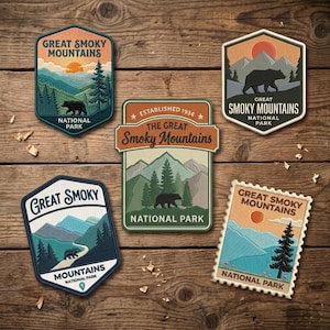 May include: Five embroidered patches featuring Great Smoky Mountains National Park designs. Each patch displays mountain landscapes, pine trees, and black bear silhouettes in various shapes, including hexagons, rectangles, and a postage stamp style.