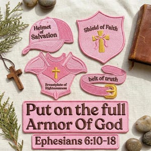 May include: A collection of pink embroidered patches featuring religious themes. The patches include a baseball cap labeled Helmet of Salvation, a shield labeled Shield of Faith, a chest piece labeled Breastplate of Righteousness, and a belt labeled belt of truth. Two rectangular patches read Put on the full Armor Of God and Ephesians 6:10-18.