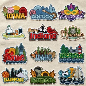 May include: A collection of twelve embroidered patches featuring various U.S. state names and iconic imagery, including a pig for Iowa, a banjo for Kentucky, a mask for Louisiana, a lighthouse for Massachusetts, a cardinal for Indiana, a wolf for Minnesota, a lobster for Maine, a butterfly for Idaho, a bridge for Michigan, a pizza for Illinois, a sunflower for Kansas, and a crab for Maryland.