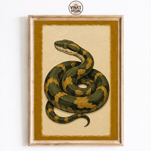 May include: A rectangular framed wall art print featuring a coiled snake with dark green and mustard yellow scales. The snake has a visible eye and is positioned against a textured cream background, surrounded by a solid mustard yellow border.