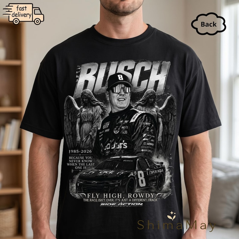 以下が含まれることがあります： レーサーのグラフィックと「BUSCH」の文字が入った黒いTシャツ。デザインには「FLY HIGH, ROWDY」と「SIDE ACTION」の文字、天使の姿、レーシングカーが含まれています。Tシャツはクルーネックです。