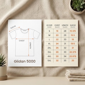 May include: A diagram of a white t-shirt with chest, length, and sleeve measurements. A size chart shows UK sizes S-5XL with chest, length, and sleeve measurements in inches. The brand name "Gildan 5000" is printed at the bottom of the diagram.