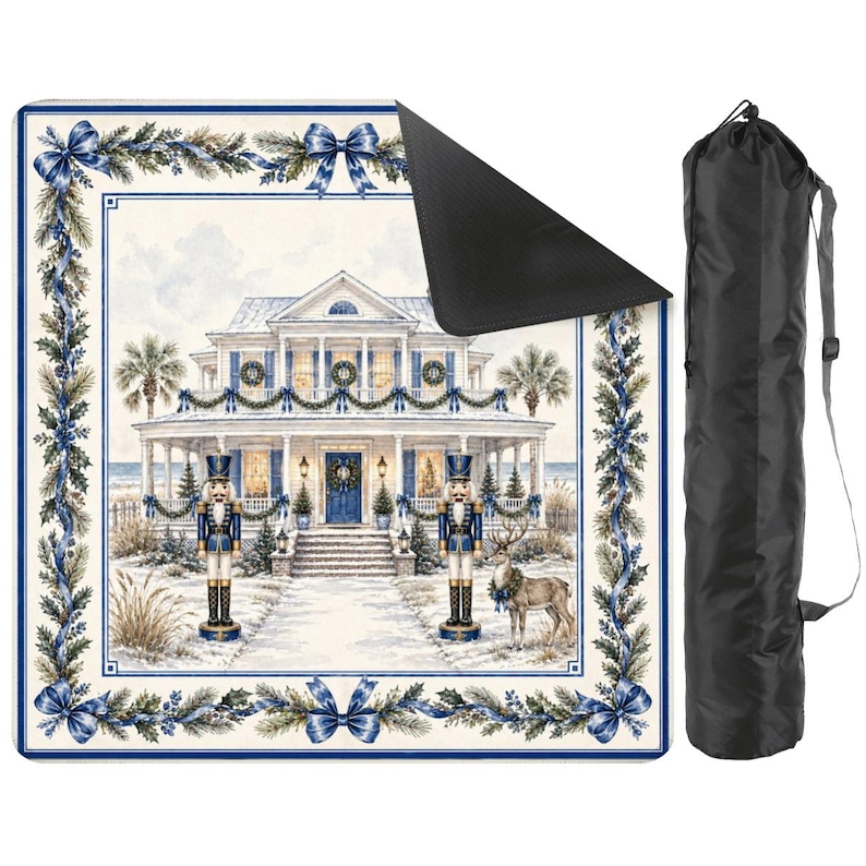 May include: A square, cream-colored outdoor blanket with a winter scene of a house, nutcrackers, and a reindeer. The blanket has a blue border with bows and greenery. A black carrying bag is included.