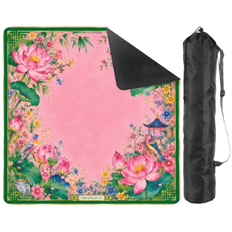 May include: A pink yoga mat with a floral design featuring lotus flowers, birds, and a pagoda. The mat has a green border and a black underside. A black carrying bag is included. The text "OAK & PALM CO." is visible.