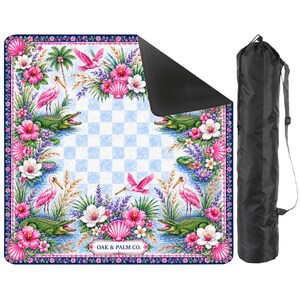 May include: A square picnic blanket with a colorful floral and wildlife design, including pink birds, alligators, and flowers. The blanket has a blue and white checkered center and a black carrying bag.
