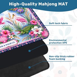 May include: A high-quality Mahjong mat with a vibrant floral and wildlife design. The mat features a pink flamingo, green alligator, and various flowers. The text "DAK & PALM CO." is visible. It has a soft tech fabric, environmental protection, and a non-slip rubber foam backing.