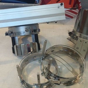 Puede incluir: Un conjunto de aros de bordado de color plateado, que incluye un aro grande con un soporte y un aro m&aacute;s peque&ntilde;o con un mango. Los aros se utilizan para el bordado y otras manualidades.