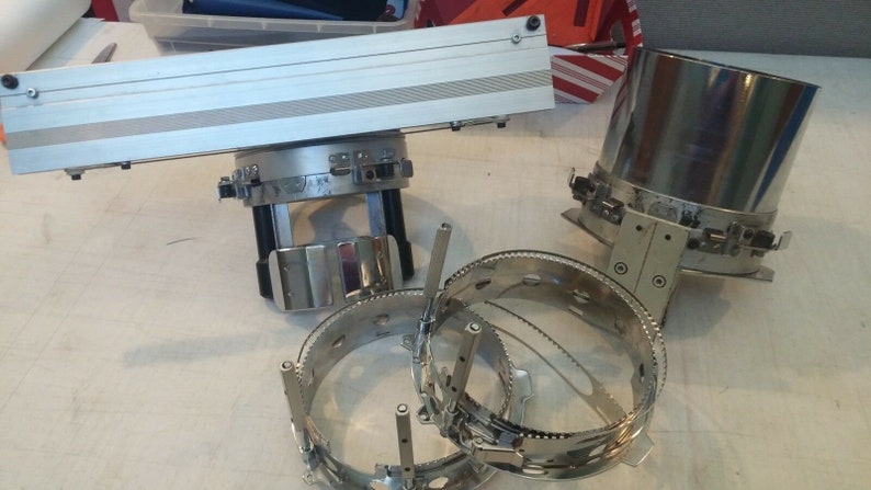 Puede incluir: Un conjunto de aros de bordado de color plateado, que incluye un aro grande con un soporte y un aro m&aacute;s peque&ntilde;o con un mango. Los aros se utilizan para el bordado y otras manualidades.