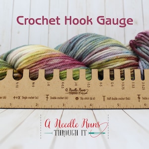 May include: A wooden crochet hook gauge with a ruler and markings for different hook sizes, including UK sizes and metric measurements. The gauge is labelled "A Needle Runs Through It".