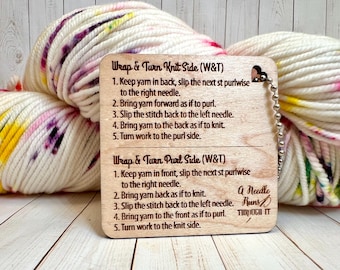 May include: A wooden knitting guide with instructions for Wrap & Turn Knit and Purl Sides, attached to a ball of white yarn with colorful speckles. The guide has a heart-shaped hole and a metal chain.