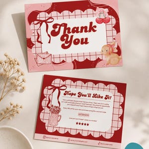 May include: Two rectangular thank you cards with a red and pink grid pattern. The top card features the text Thank You, a pair of cherries, a bow, and a rabbit. The bottom card displays Hope You'll Like It, a flower vase, and a discount code.