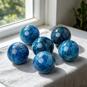 Esfera de apatita azul cristalina natural, bola pulida a mano con vetas naturales para decoración del hogar.