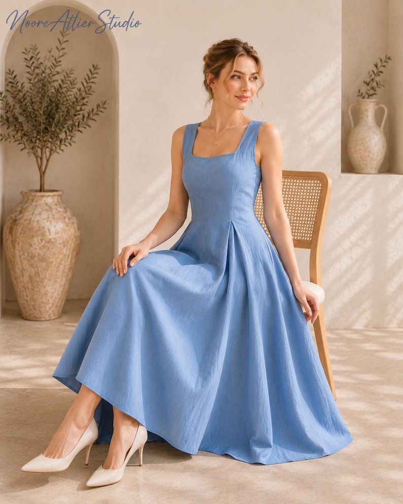 May include: A sleeveless cornflower blue midi dress with a square neckline, a fitted bodice, and a pleated skirt that flares out from the waist. The dress features a solid color and a textured fabric finish, paired with pointed-toe beige heels.