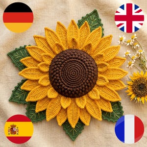 May include: A crocheted sunflower with a dark brown textured center and multiple layers of bright yellow petals. The flower is surrounded by several green crocheted leaves with visible stitched veins, creating a detailed floral design.